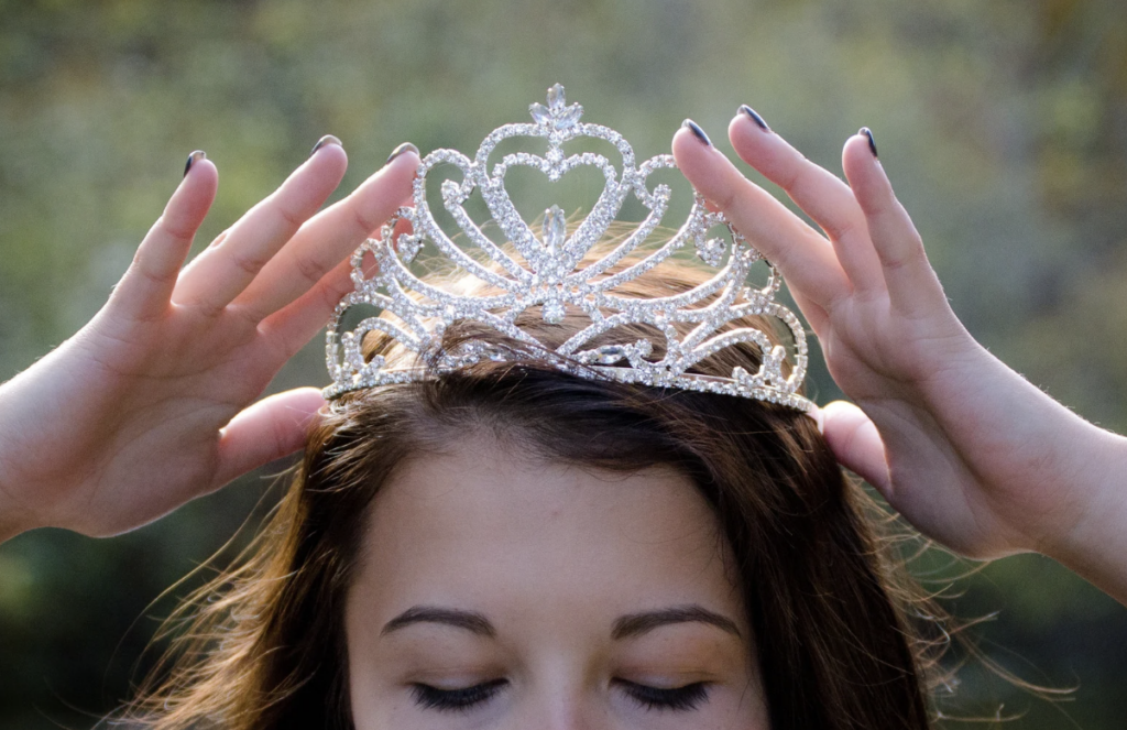 A person puts sparkly crown on their head